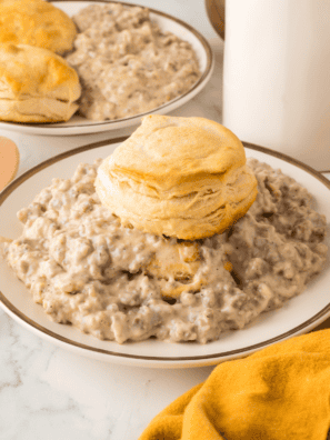 Bob Evans sausage gravy recipe ladled over two split buttermilk biscuits on a white plate
