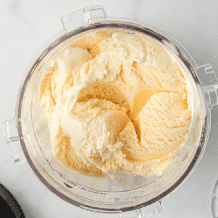 Carton of vanilla ice cream softening on the counter beside the spice base for an Autumn Spice Milkshake