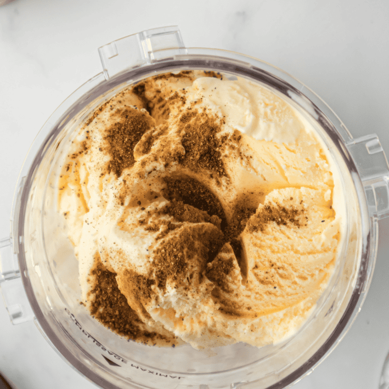 Pouring the cinnamon spice base over vanilla ice cream in a blender for a copycat Autumn Spice Milkshake