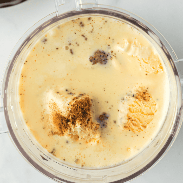 Stirring crushed brown sugar cookies into a blended cinnamon milkshake before pouring into chilled glasses