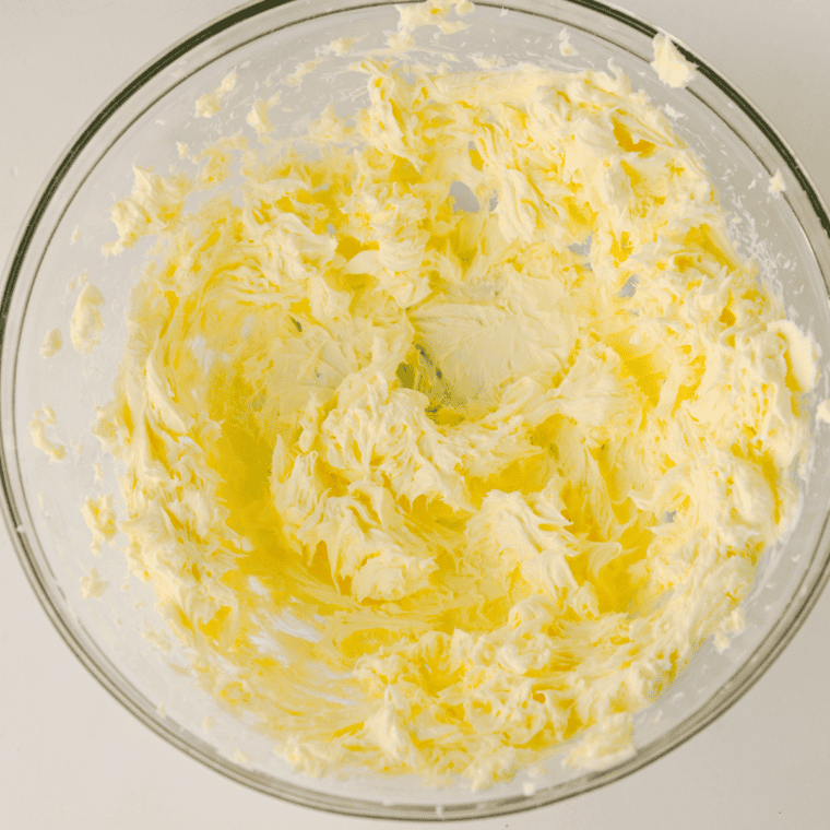 Cream cheese and butter beaten smooth in a glass mixing bowl with an electric hand mixer