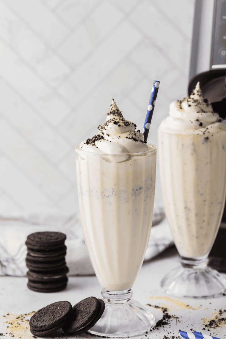 Finished shake poured into a chilled glass and topped with whipped cream, crushed cookies, and a cherry