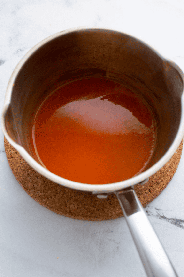 Whisking buffalo sauce in a saucepan on the stove