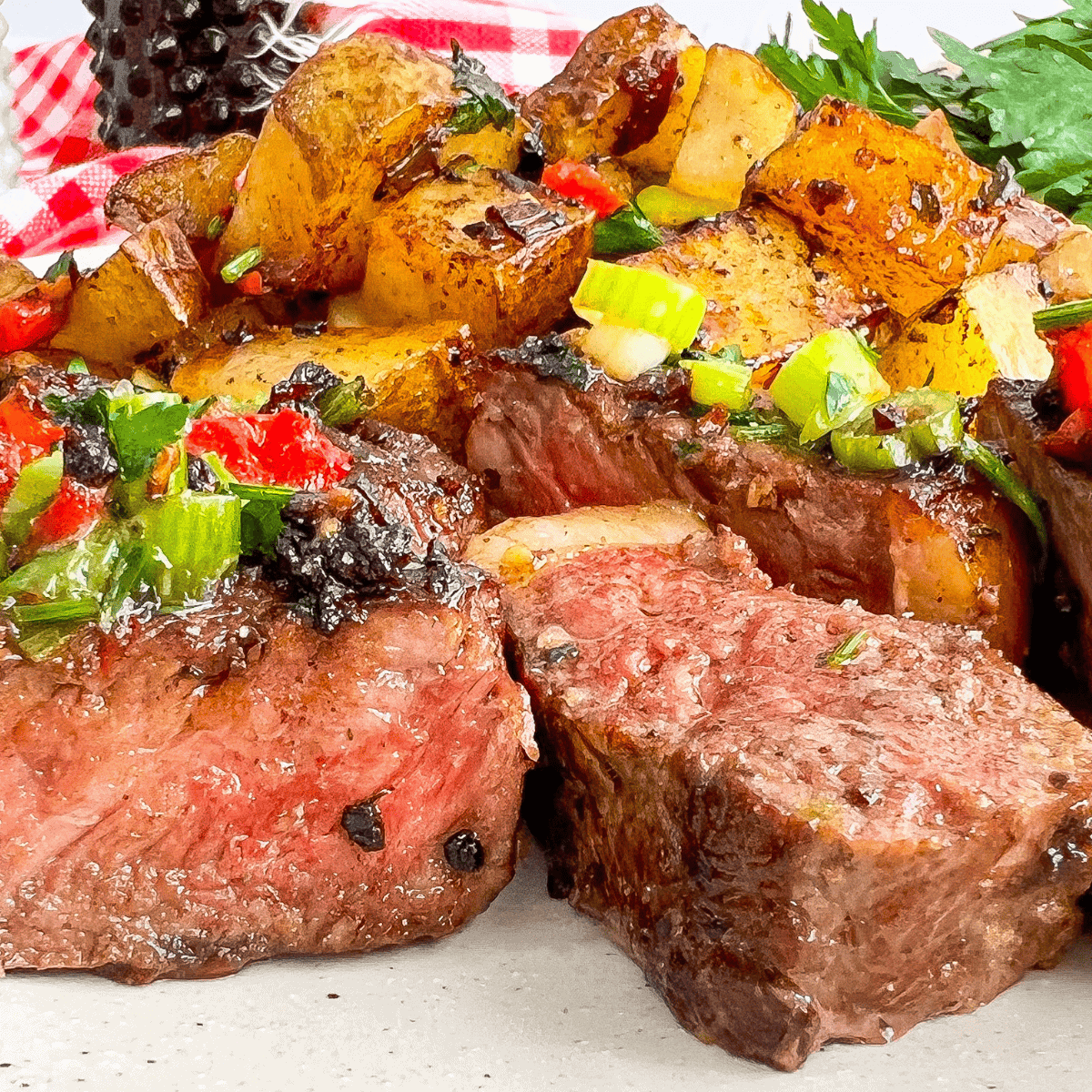 Grilled ribeye on a plate coated in homemade buttery garlic and herb seasoning with a sprig of thyme
