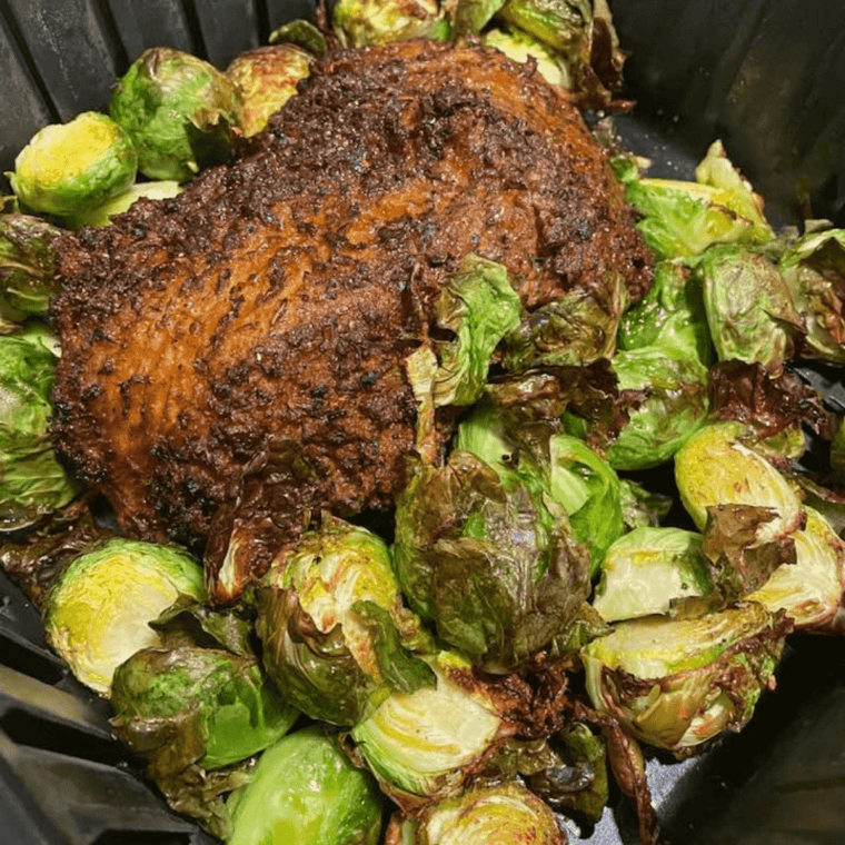 Santa Maria seasoned tri tip roast cooked in an air fryer basket with a browned peppery crust