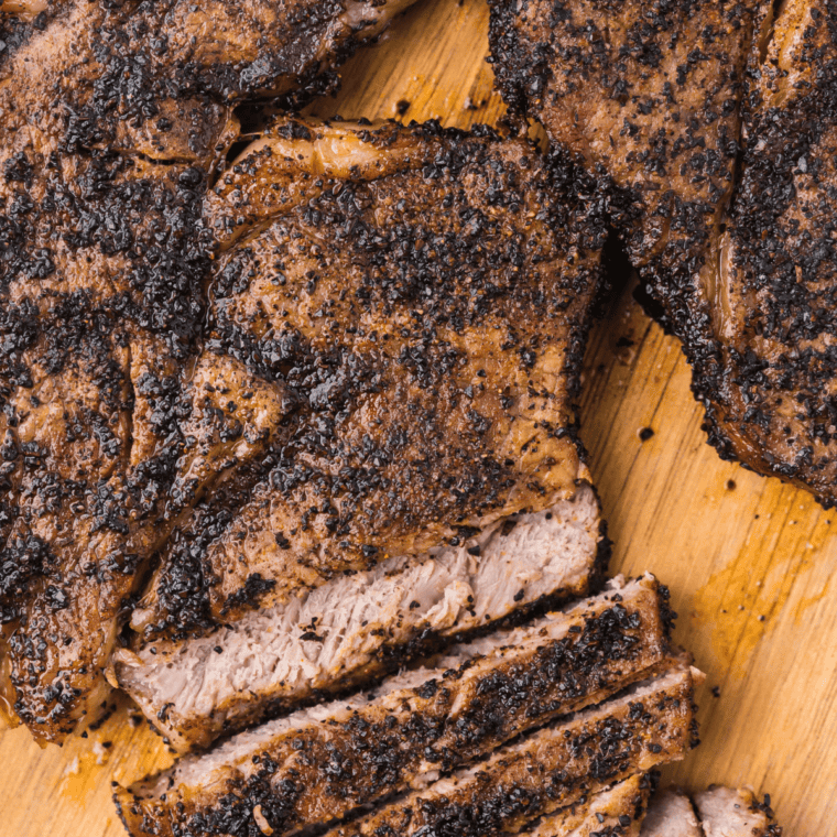 Grilled steak with a dark peppery Santa Maria rub crust, sliced to show medium-rare center
