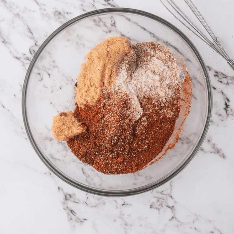 Salt, granulated garlic, black pepper and paprika measured into a bowl for Santa Maria seasoning
