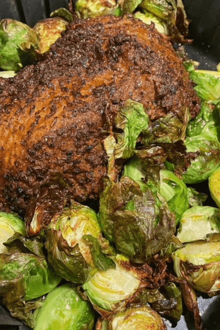 Cooked Santa Maria tri tip roast with a dark garlic and pepper crust, resting on a cutting board