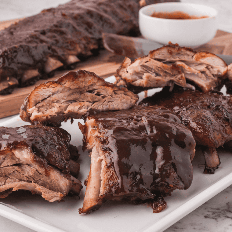 Cooked ribs with a dark garlic and pepper crust from Santa Maria seasoning, sliced on a board