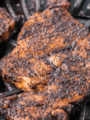 Ribeye steak coated in copycat Kinder's Woodfired Garlic seasoning grilling over open flame