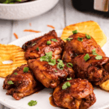Grilled chicken thighs coated in copycat Lawry's Baja Chipotle Marinade, served on a platter with lime wedges and cilantro