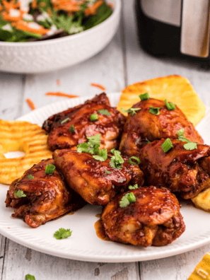 Grilled chicken thighs coated in copycat Lawry's Baja Chipotle Marinade, served on a platter with lime wedges and cilantro