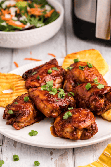Grilled chicken thighs coated in copycat Lawry's Baja Chipotle Marinade, served on a platter with lime wedges and cilantro