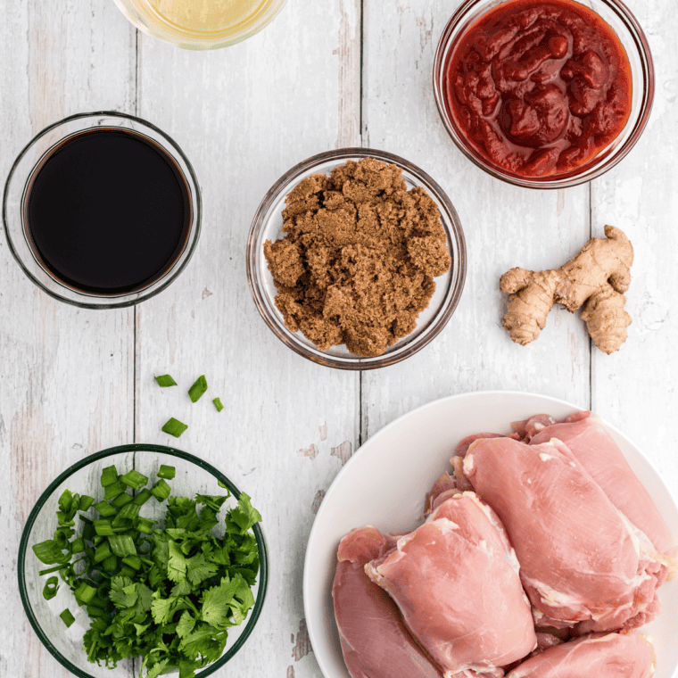 Ingredients for copycat Lawry's Baja Chipotle Marinade on a marble counter, including limes, tomato paste, chipotle powder, cumin, oregano, and white vinegar