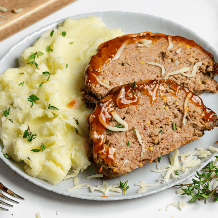 Slice of copycat McCormick meatloaf on a white plate with ketchup glaze