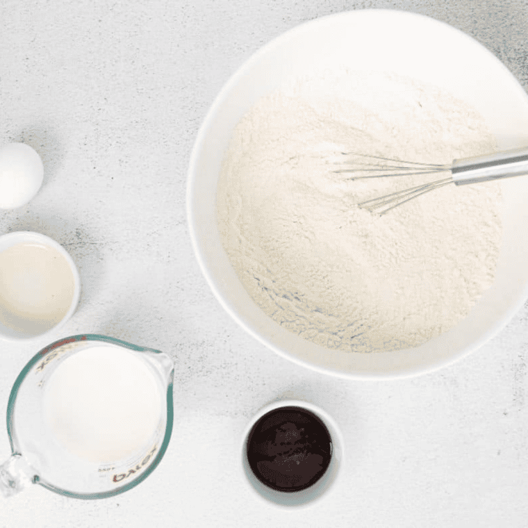 Flour, milk powder, chicken bouillon, and spices for homemade turkey gravy mix in a bowl