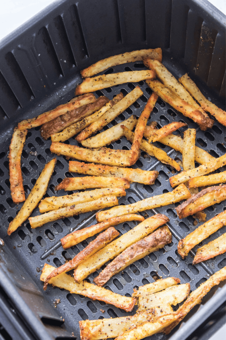 Hot Aussie fries spread on a sheet pan and blanketed with freshly shredded Monterey Jack and sharp cheddar
