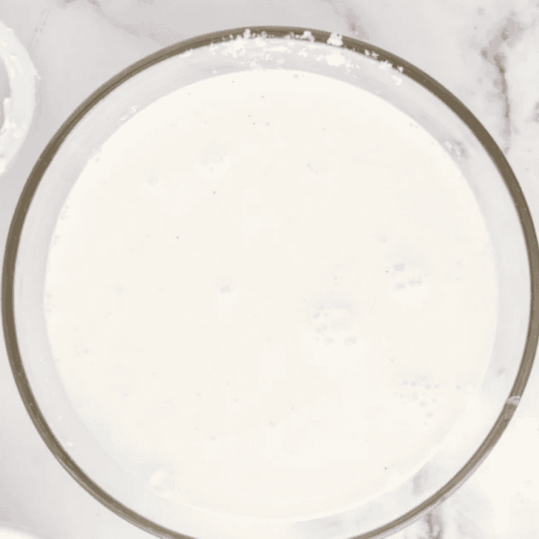 Blending malted milk powder, whole milk, and sweetened condensed milk in a blender until smooth
