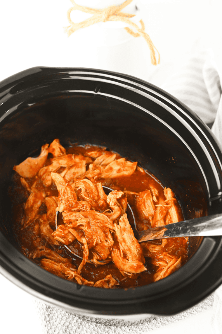 Cooked chicken breasts in a crockpot surrounded by salsa after slow cooking