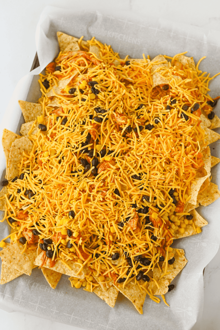 Crockpot chicken nachos fresh from the broiler with melted bubbling cheddar cheese