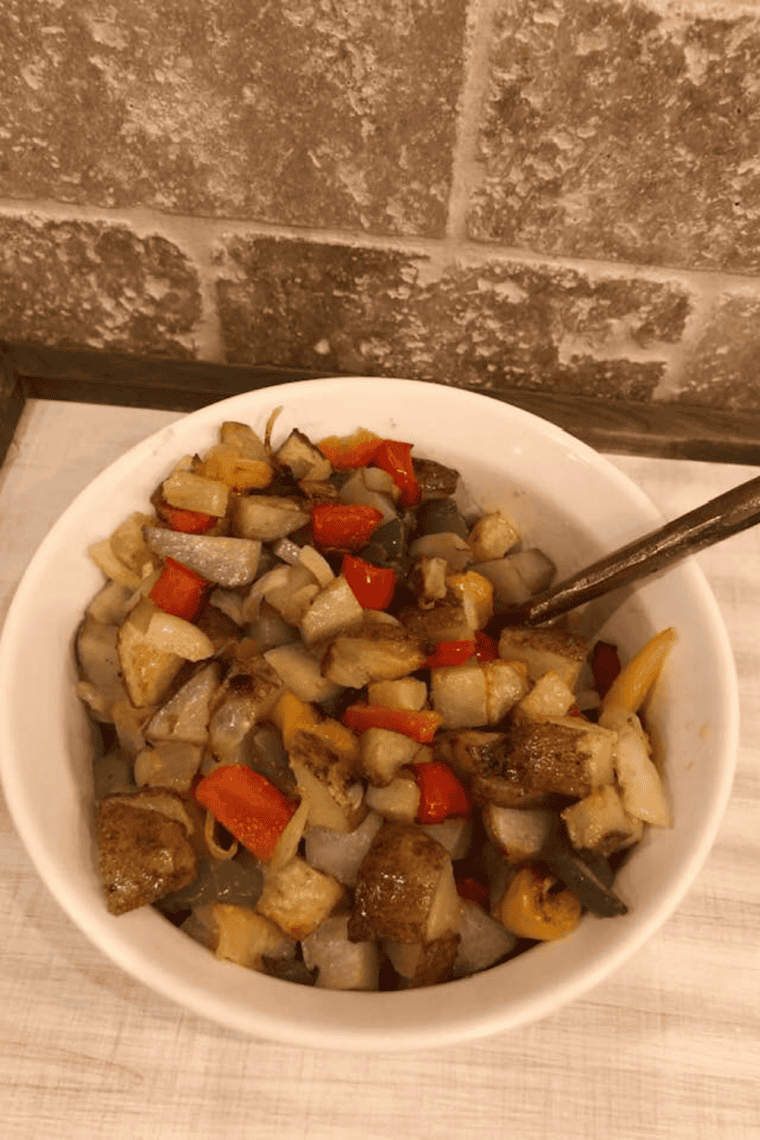 Seasoning tossed through finished Denny's home fries in the skillet