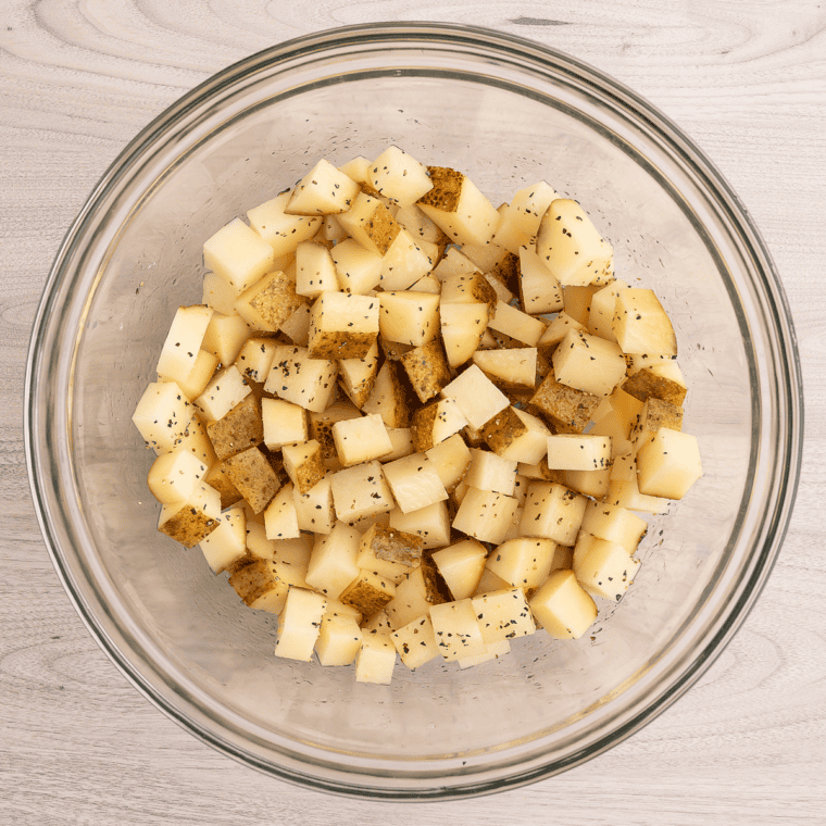 Diced red potatoes with skin on in a pot of salted water, ready to parboil