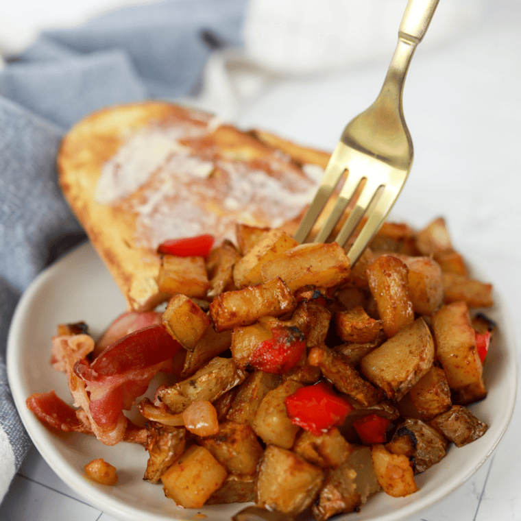 Crispy Denny's home fries copycat with diced red potatoes and onions in a cast iron skillet