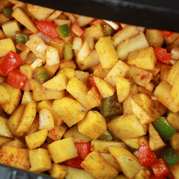 Potato cubes in a single layer in a hot cast iron skillet, browning undisturbed
