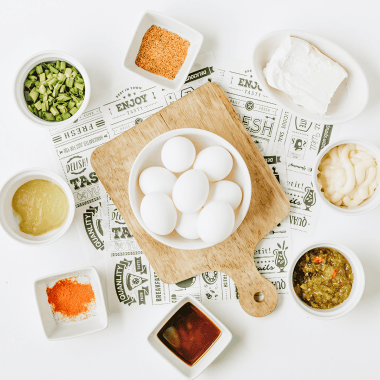 Deviled egg dip ingredients including eggs, Duke's mayo, cream cheese, sweet pickle relish, Dijon mustard, and Cajun seasoning