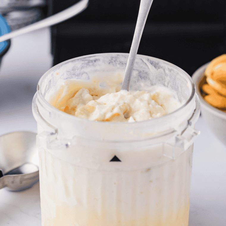 Ninja Creami pint of Greek yogurt frozen yogurt beside a tub of plain Greek yogurt and a jar of honey