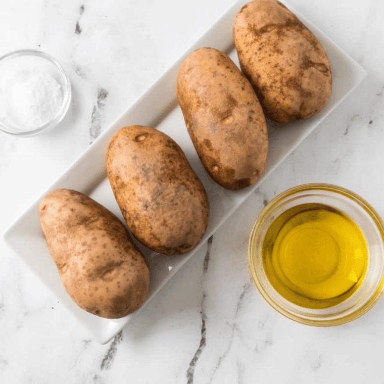Scrubbed russet potatoes patted completely dry on a kitchen towel