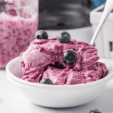 Ninja Creami blueberry frozen yogurt in a bowl topped with fresh blueberries
