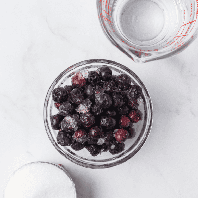 Greek yogurt, blueberries, a lemon, milk, and sugar on a counter