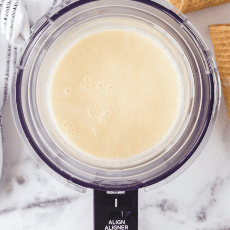 Cheesecake frozen yogurt base poured into a Ninja Creami pint below the MAX FILL line