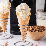 Ninja Creami Copycat Baskin Robbins Old Fashioned Butter Pecan ice cream in a waffle cone with toasted pecans