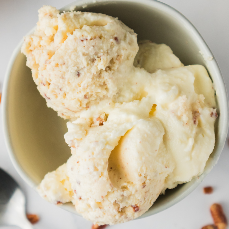 Bowl of homemade butter pecan ice cream topped with toasted pecans