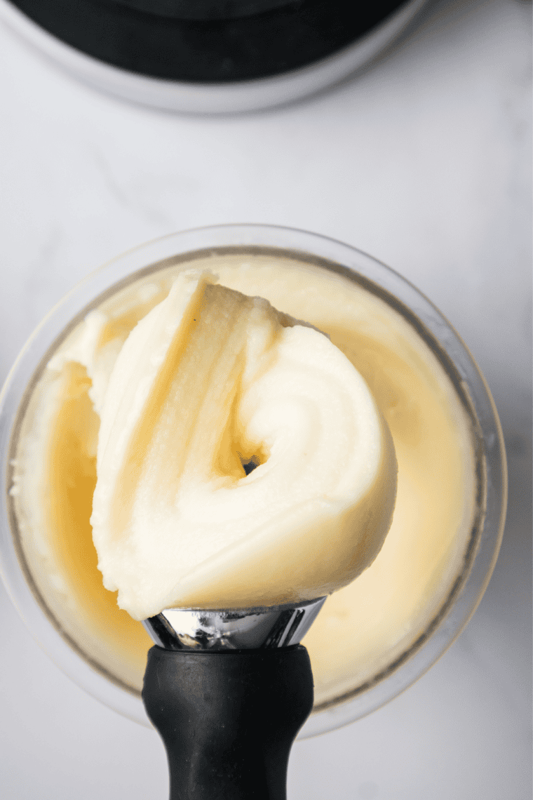 Creamy pineapple Dole Whip made in the Ninja Creami, served in a chilled cup with a spoon