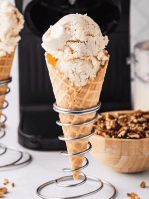 Scoop of Ninja Creami gooey butter cake ice cream in a pint container with cake crumbles and a gooey condensed milk swirl