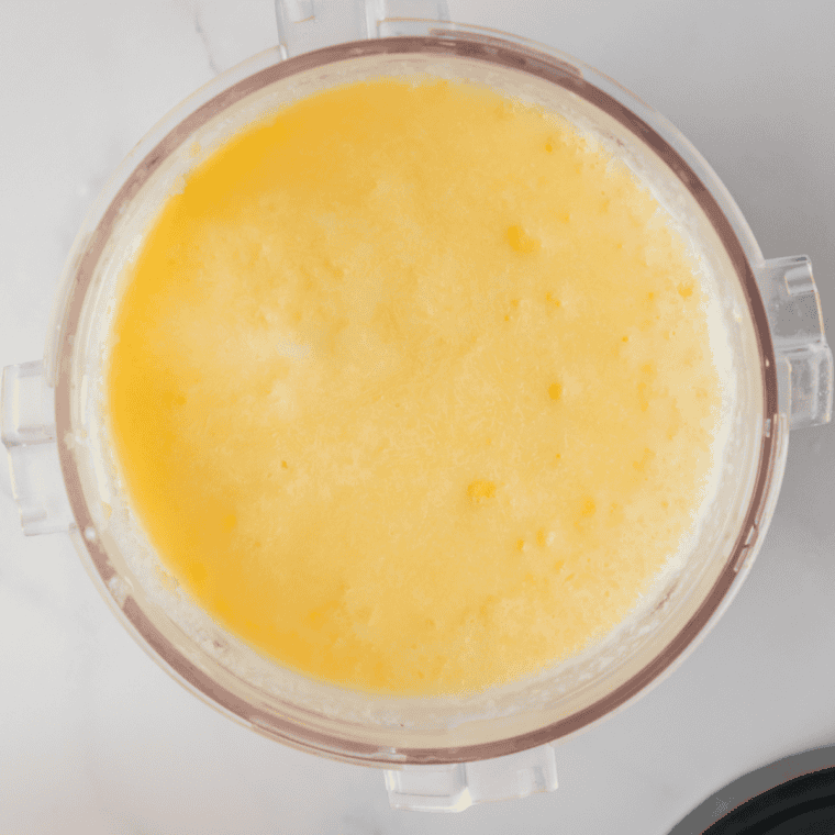 Ninja Creami pint filled to just below the max fill line with pale yellow ice cream base