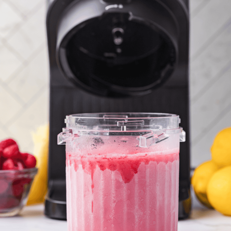 Strained raspberry lemonade base filled to the max line in a Ninja Creami pint