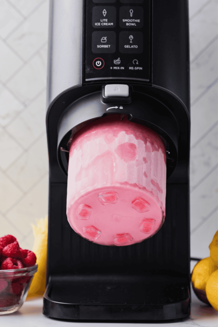 Frozen raspberry pint locked into the Ninja Creami on the Sorbet setting