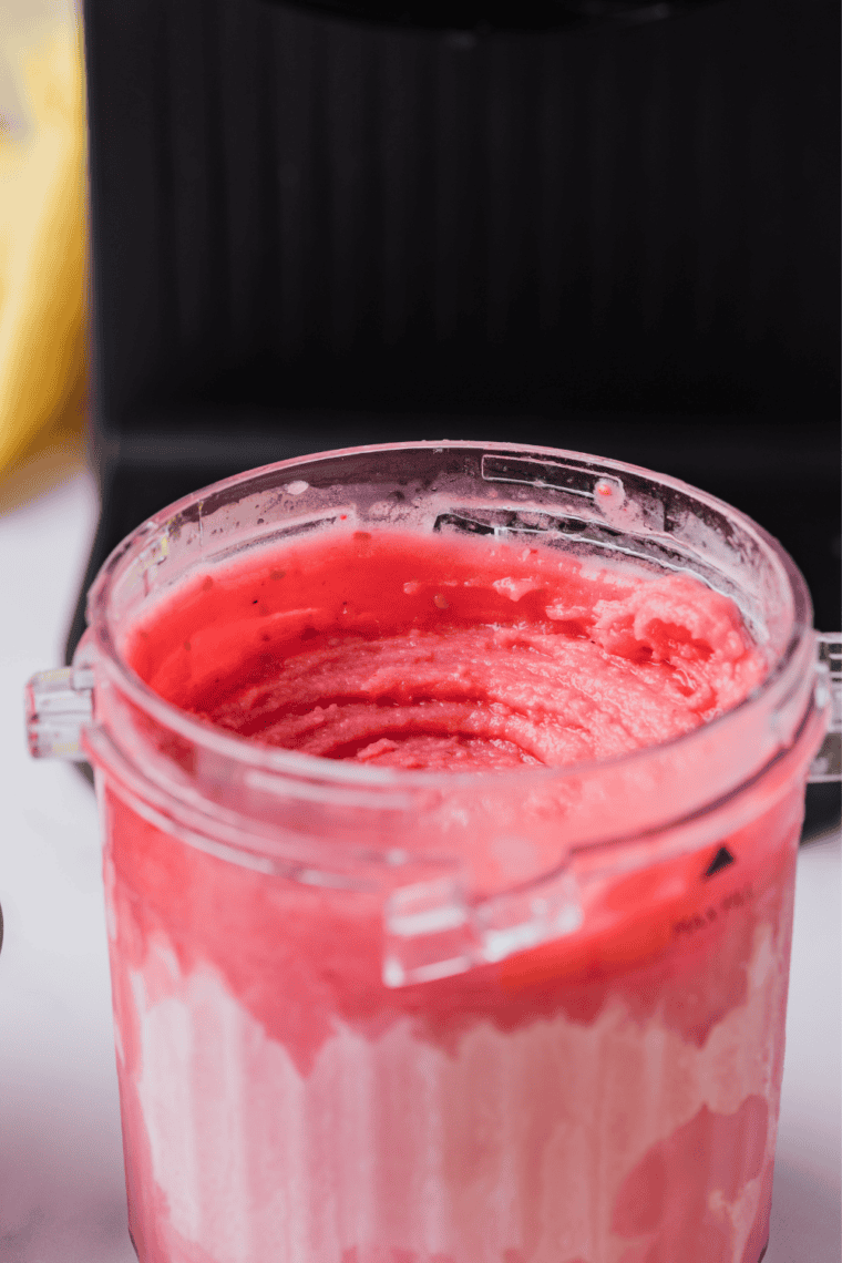 Scoop of bright pink raspberry lemonade sorbet in a Ninja Creami pint