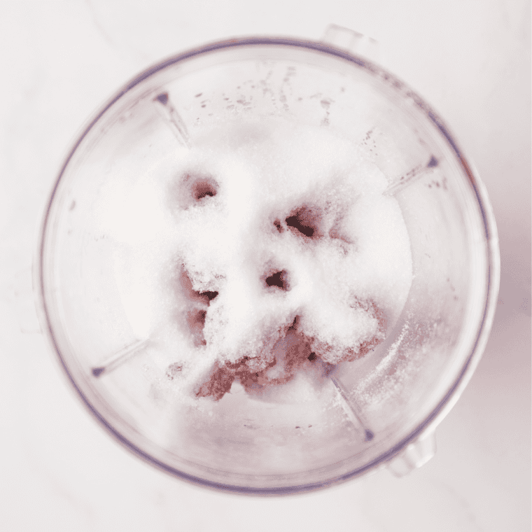 Granulated sugar measured in a bowl for raspberry lemonade sorbet