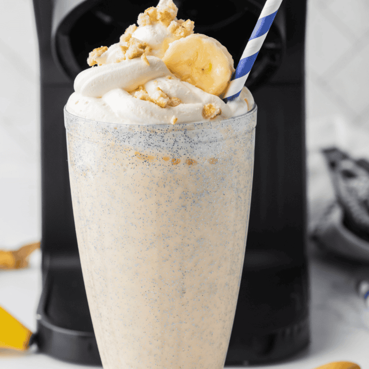 Thick Ninja Creami Steak 'n Shake banana shake in a tall glass topped with whipped cream and a maraschino cherry