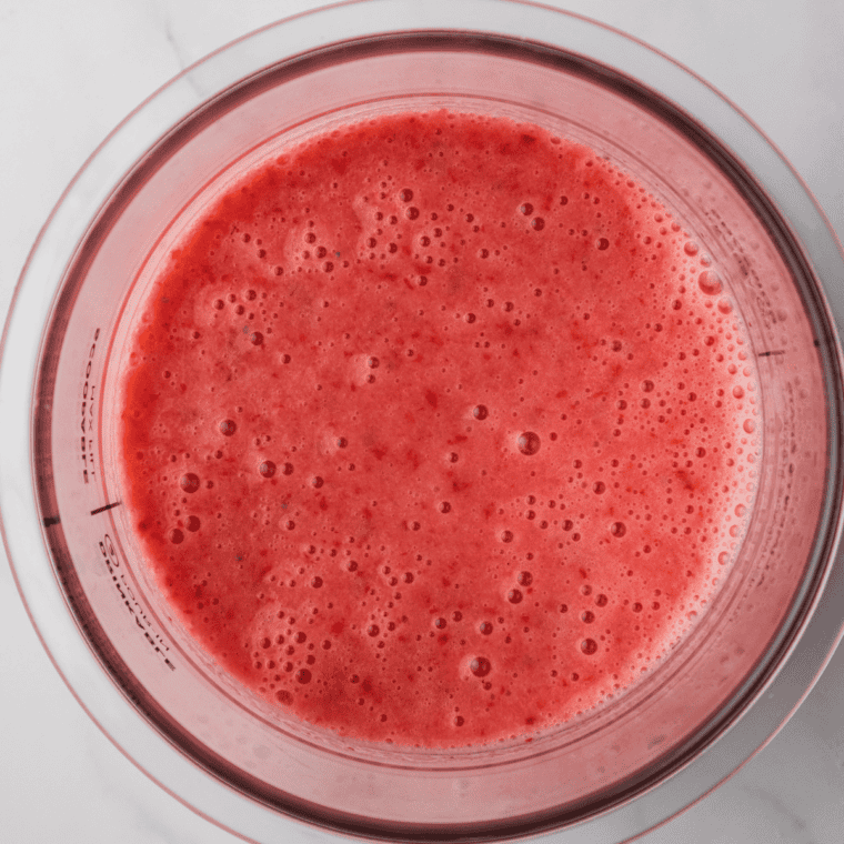 Blender filled with pink strawberry Greek yogurt ice cream base
