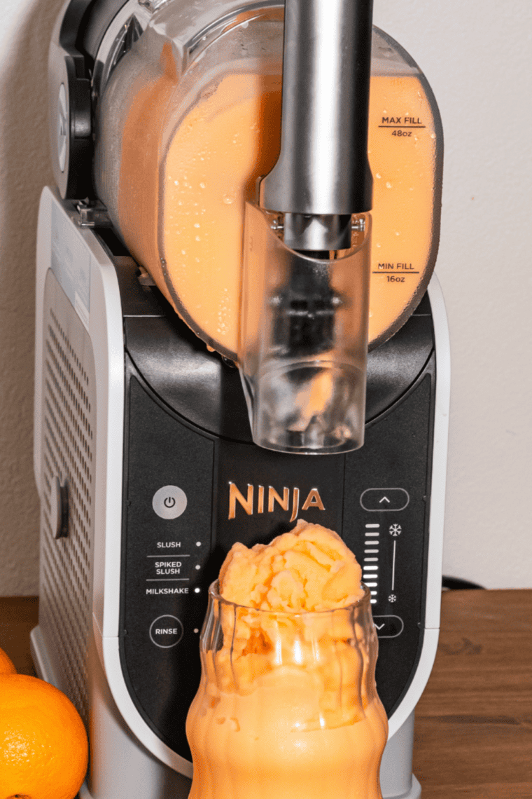 Ninja Slushi frozen drink maker filled with red slush and an anti-drip pour spout