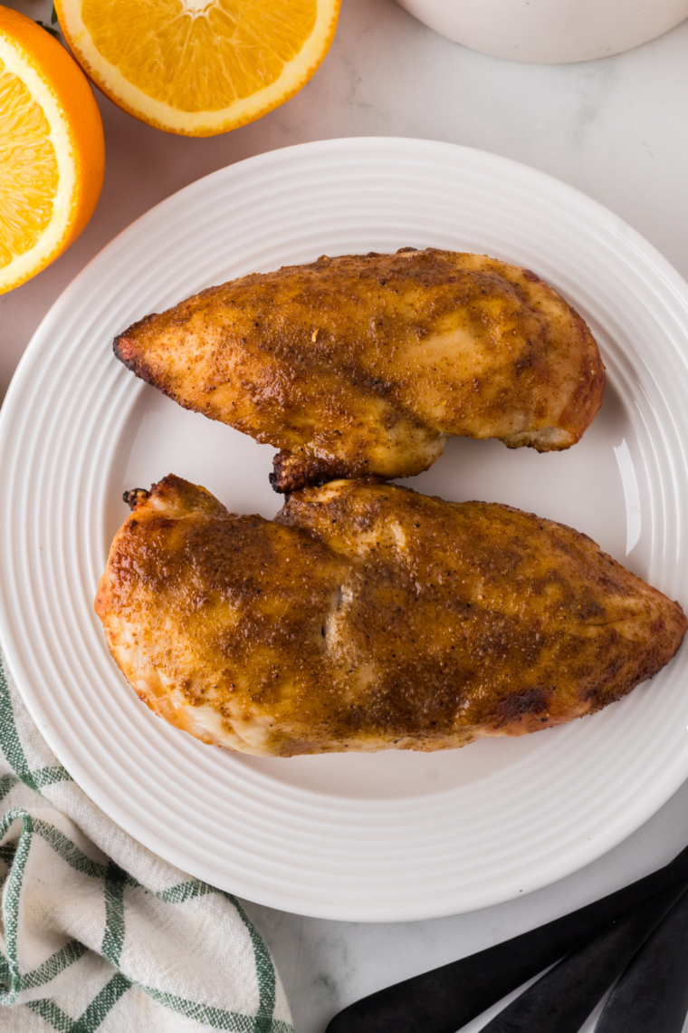 Cooked turkey breast slices on a white plate with crisp golden skin