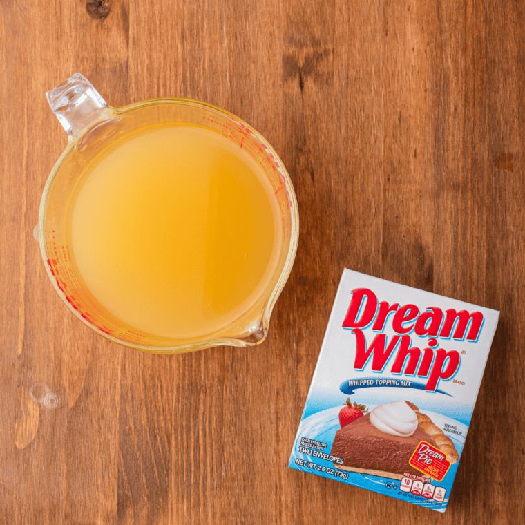 Pineapple juice and a Dream Whip envelope on a wooden table