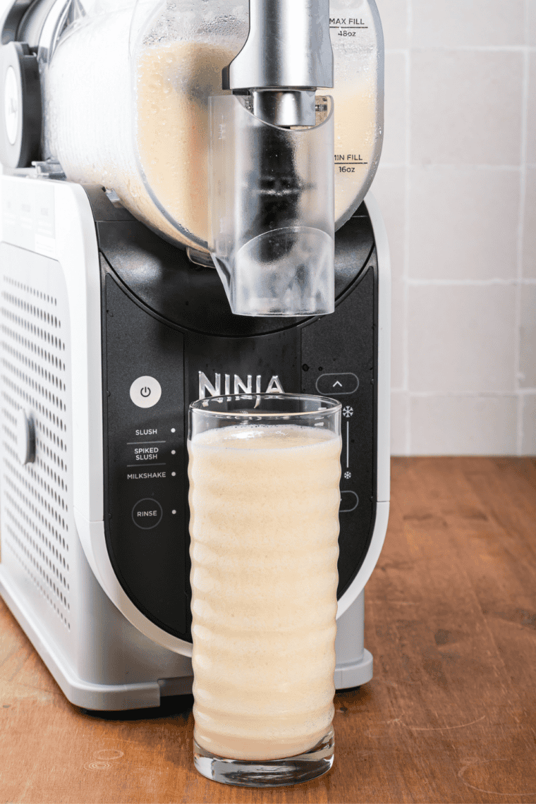 Pineapple juice and Dream Whip mixture being poured into the fill port of a Ninja Slushi