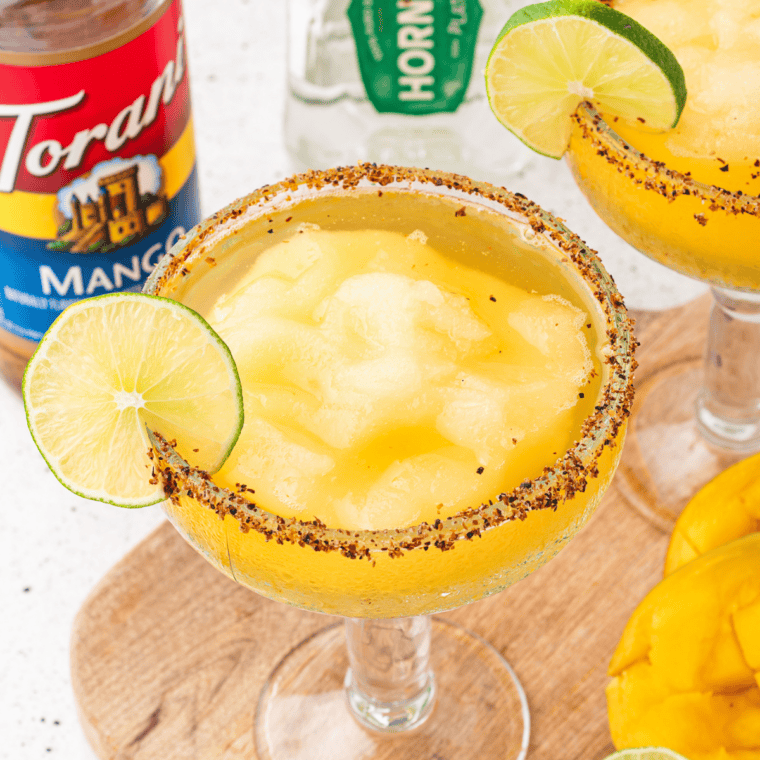 Ninja Slushi dispensing a frozen lime margarita into a salt-rimmed glass